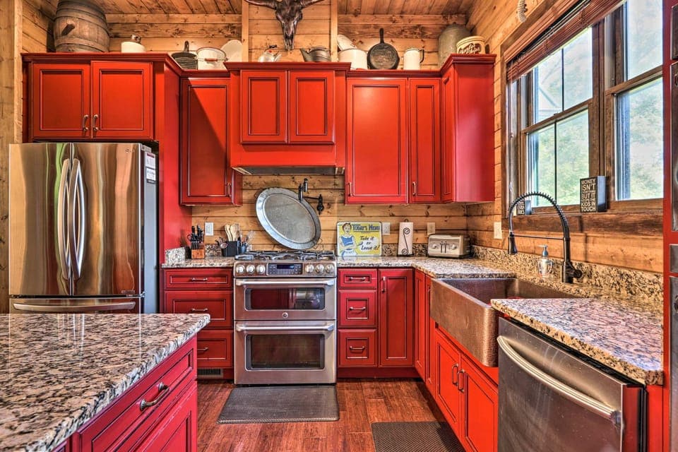 Vibrant red cabinets and granite counters inspire culinary adventures in this charming space!