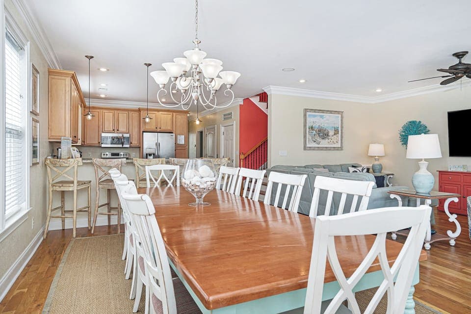 Gather around this spacious dining table where your group can share meals and stories, flowing seamlessly into the bright kitchen.
