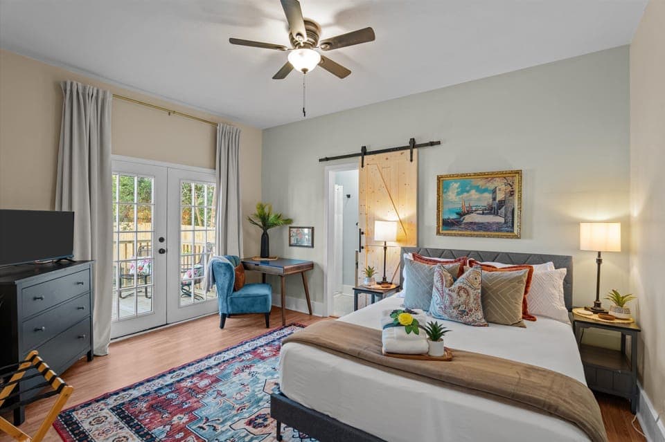 queen bedroom with dedicated workspace, smartTV, en-suite bathroom, and patio access