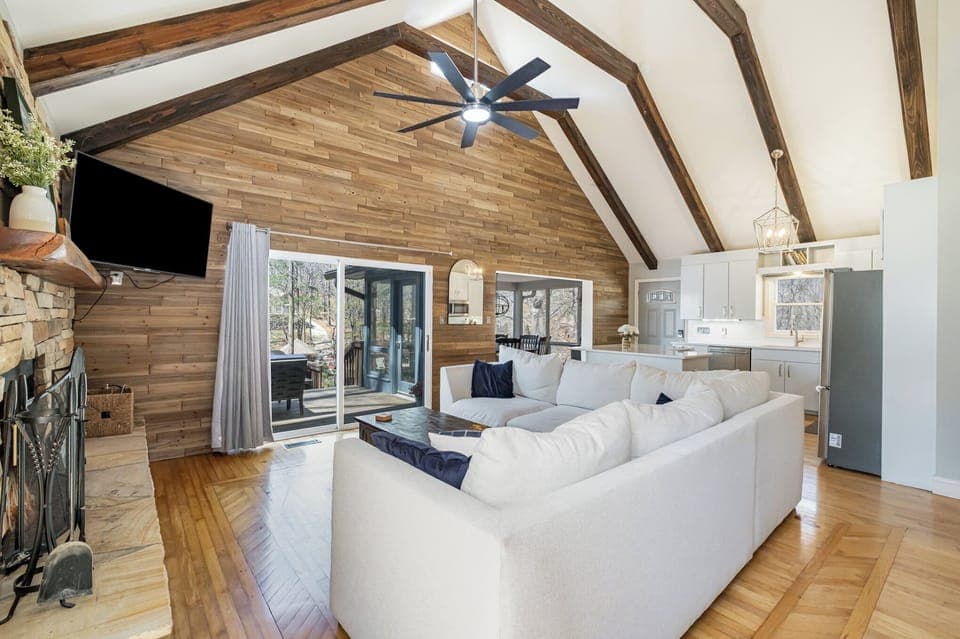 Living area with large, sectional, fireplace, TV and sliders to the deck.