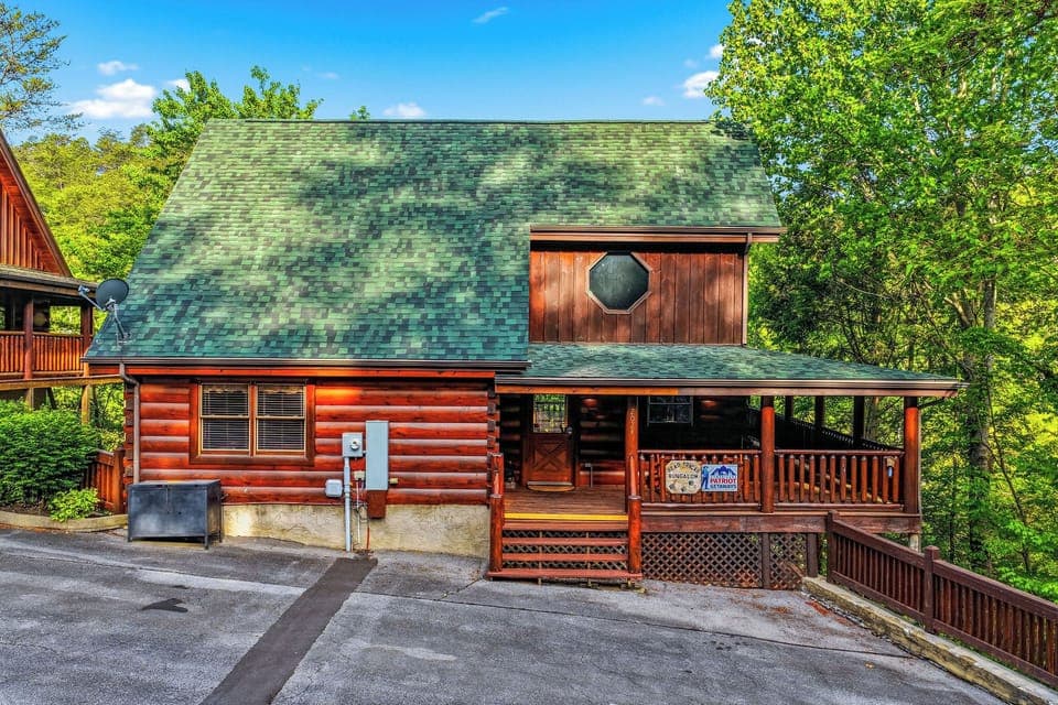Charming log cabin featuring a wraparound deck and mountain setting surrounded by lush forest.