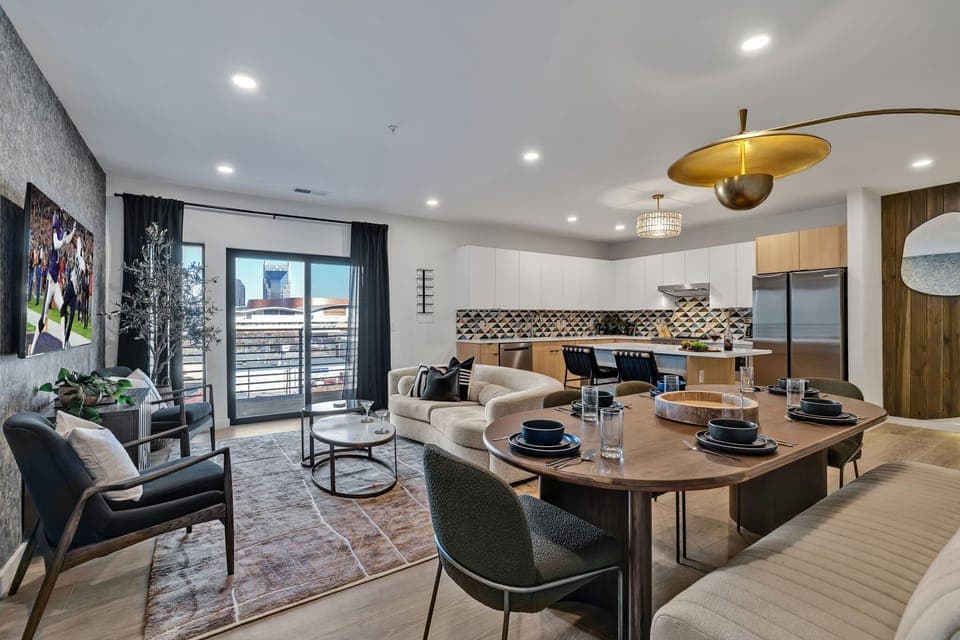 Unit 1: Bright open living space featuring smart flat-screen TV, designer furnishings, and access to a large corner private balcony.