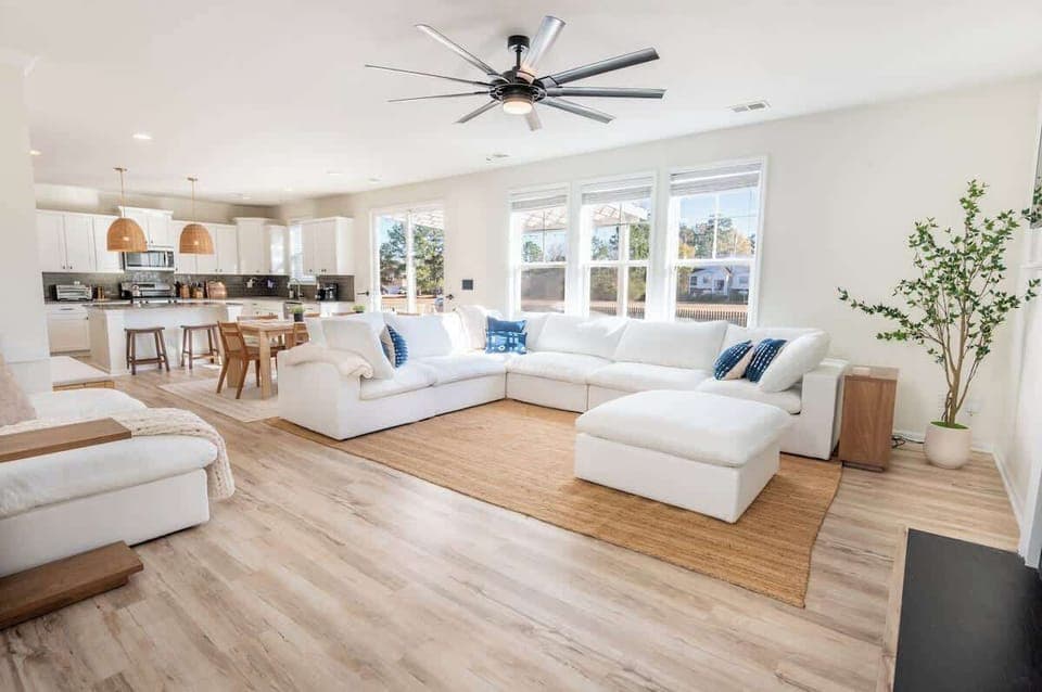 Bright open-concept living space with oversized sectional and natural light throughout.