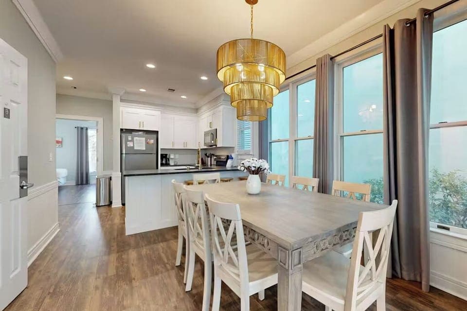 Your elegant dining room flows seamlessly into a fully-equipped kitchen, perfect for sharing memorable meals together under the warm glow of the statement chandelier.