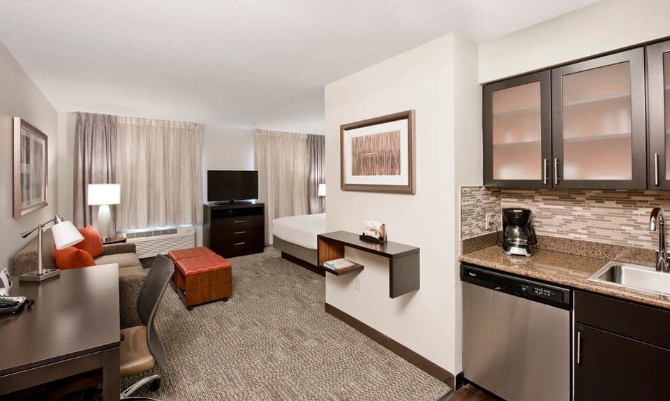 The spacious studio layout includes a queen bed, sleeper sofa, and work desk.