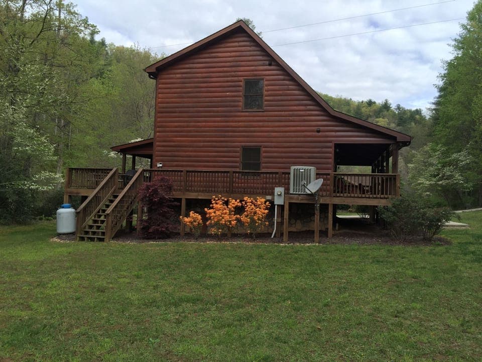 Side view of cabin with large grassy area 