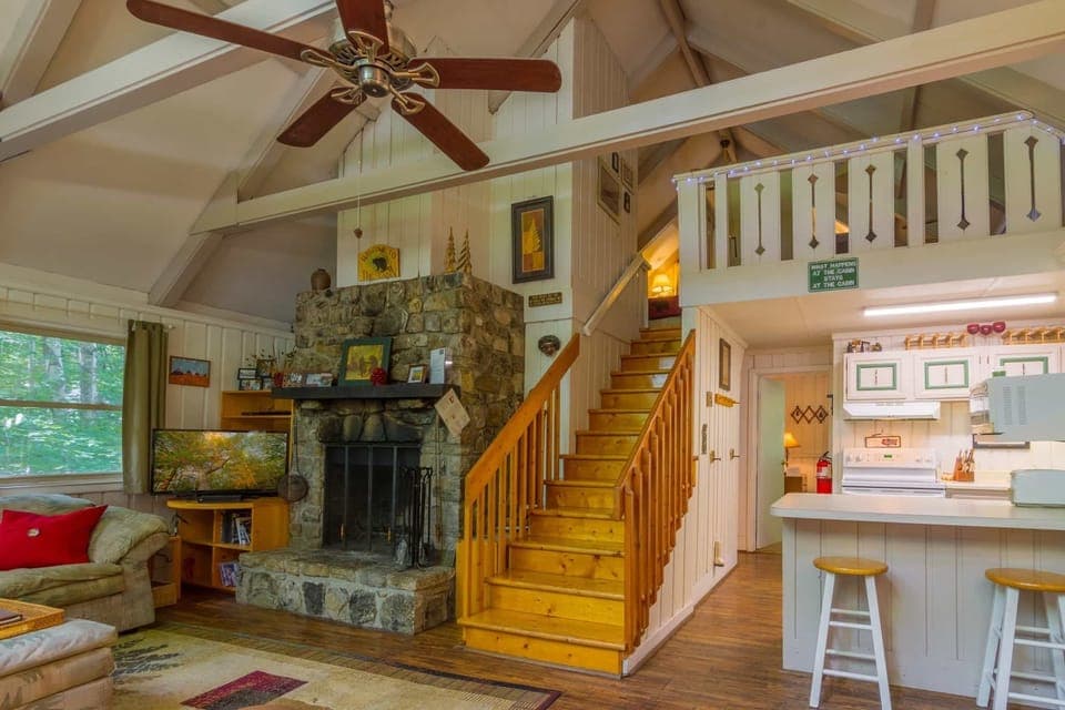 Benzine Farm Stone Fireplace, Flat Screen TV in Living Room; Stairs to Loft Viewed from Main Entry