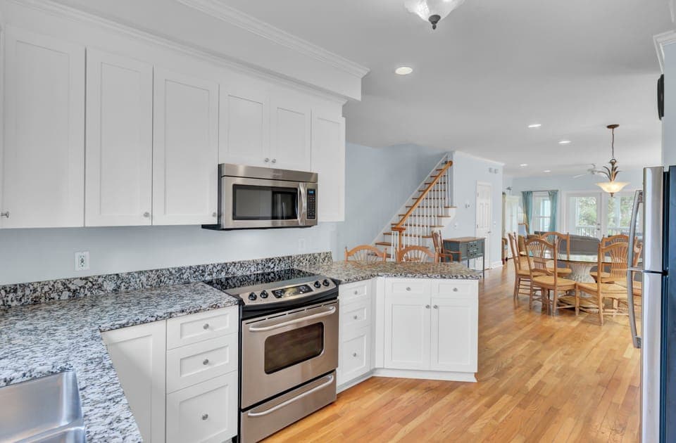 Step into your spacious kitchen with gleaming granite counters and stainless steel appliances, flowing seamlessly into the bright dining area.