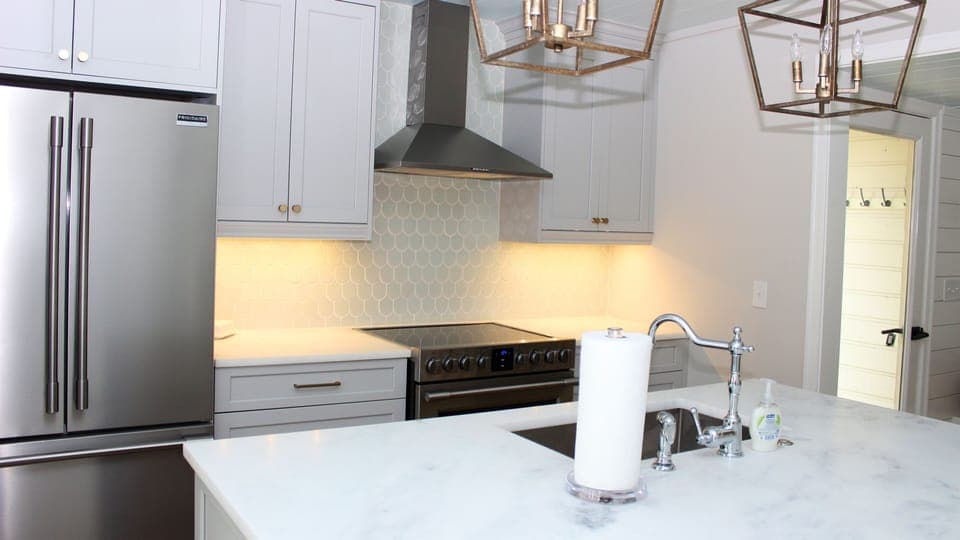 Features include new appliances, beautiful honed marble counters, and a soft green tile.