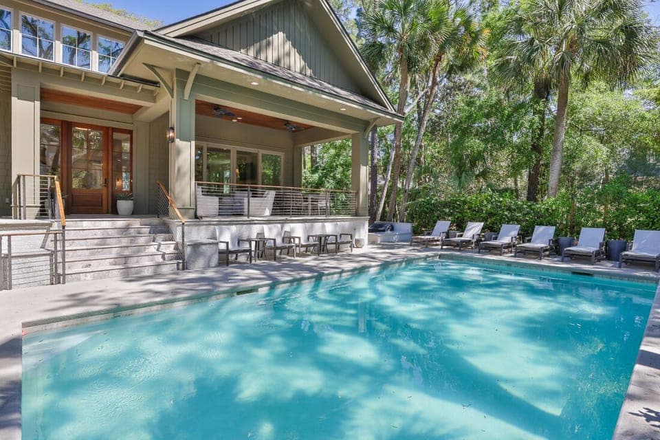 Large pool with 6 chaise lounges and 4 chairs.