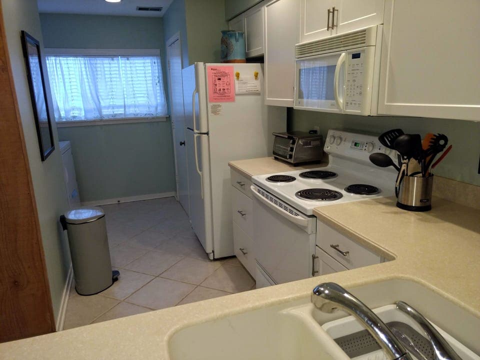 Large pantry for countertop appliances & ironing board across from laundry area.