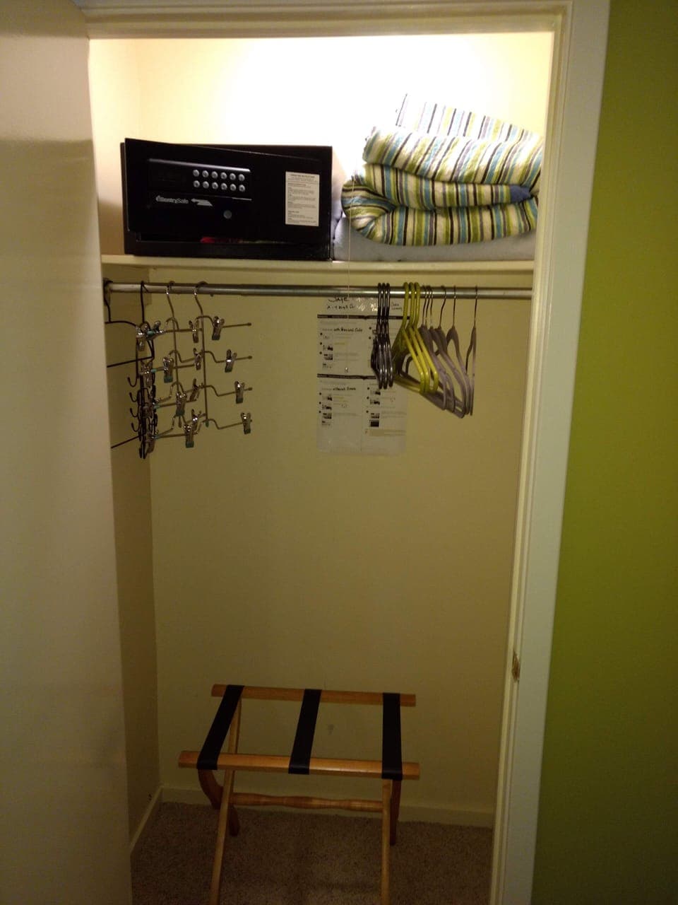 Spacious master closet with hotel safe, extra bedding, luggage rack and hangers.