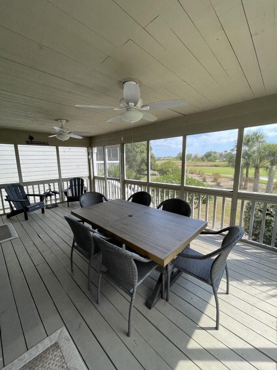 The porch has an outdoor dining area for 6 and 2 Adirondack chairs.