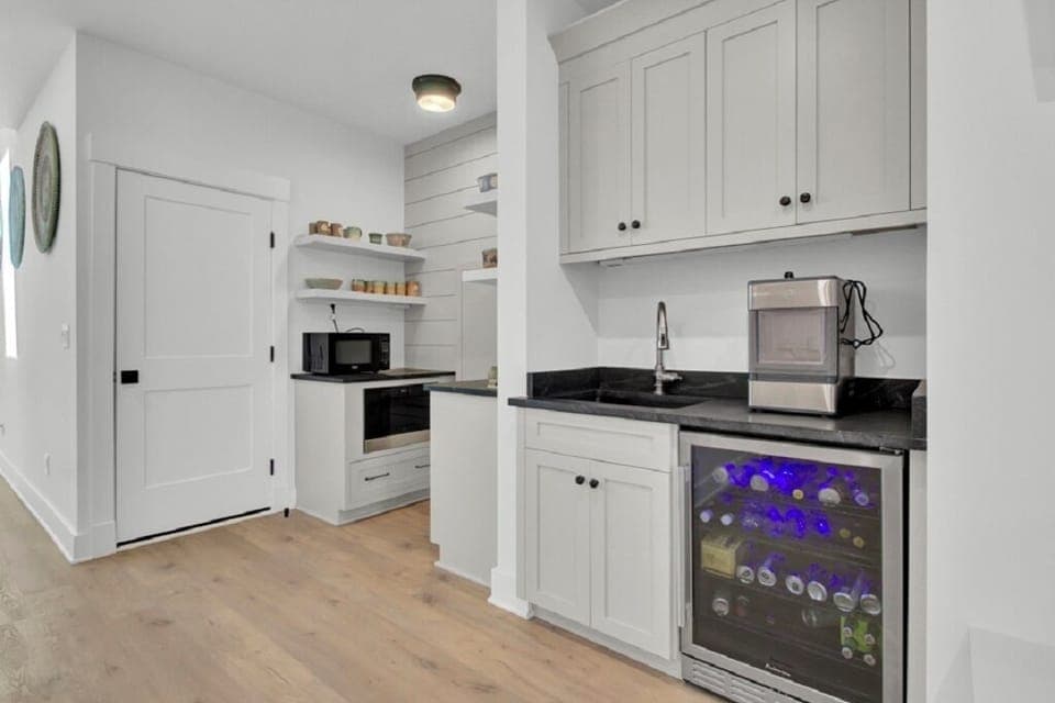 - Stocked mini fridge, ice maker, and sleek black counters create a stylish refreshment zone - Open shelves and built in microwave make snack prep quick and easy - Great for morning coffee, evening cocktails, or anytime in between