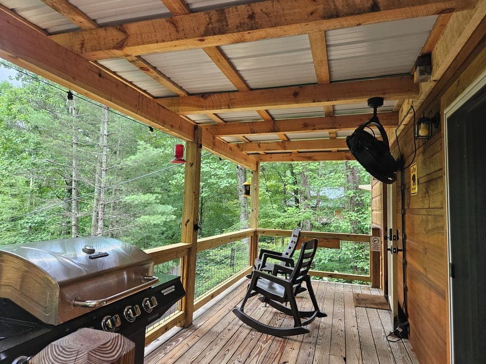 New covered deck with grill, rocking chairs, and fan.
