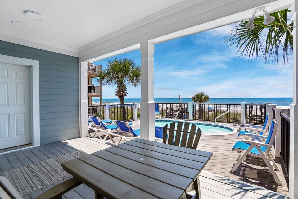 Your covered deck overlooks a sparkling private pool and endless ocean views, where coastal breezes and swaying palms create your perfect beach retreat.