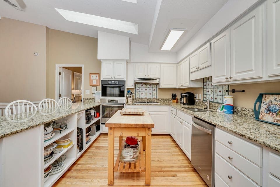 Your fully equipped kitchen awaits with granite countertops, custom cabinetry, and a charming butcher block island for preparing meals together.
