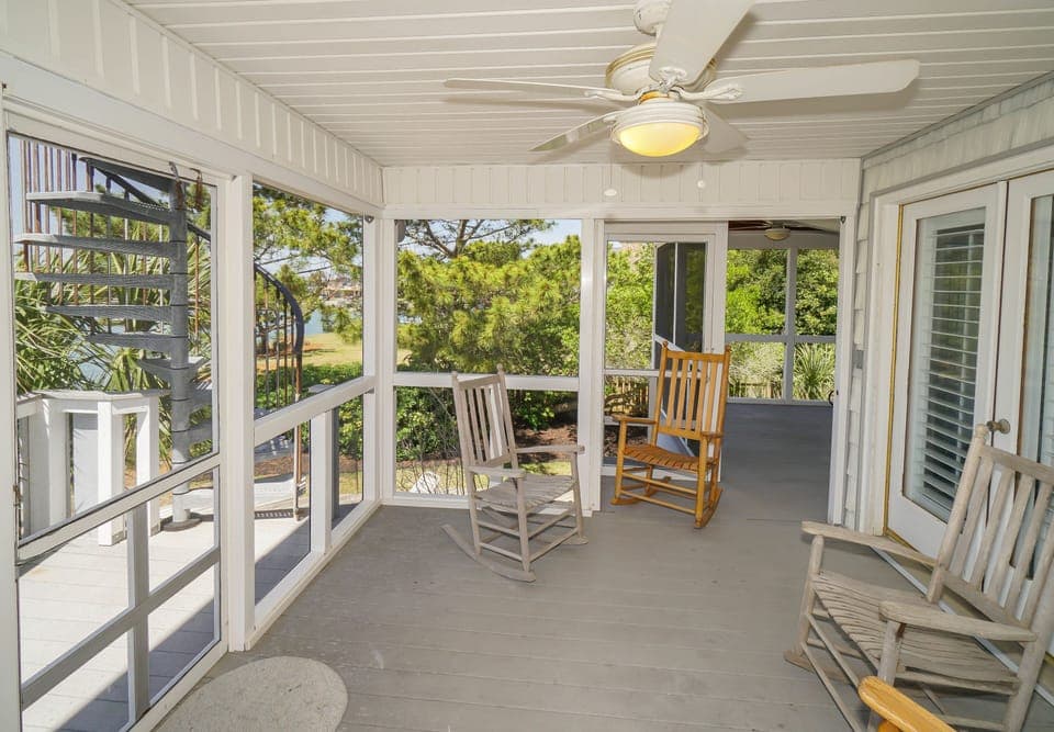 Unwind on your screened porch with rocking chairs and peaceful garden views, where gentle breezes and natural light create the perfect retreat.