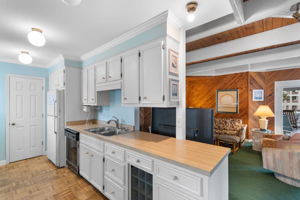 Your fully equipped kitchen features crisp white cabinets and wood countertops, perfect for preparing meals in this charming space.