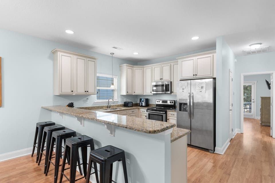 Your spacious kitchen features granite countertops, stainless steel appliances, and a breakfast bar perfect for morning coffee or casual meals.