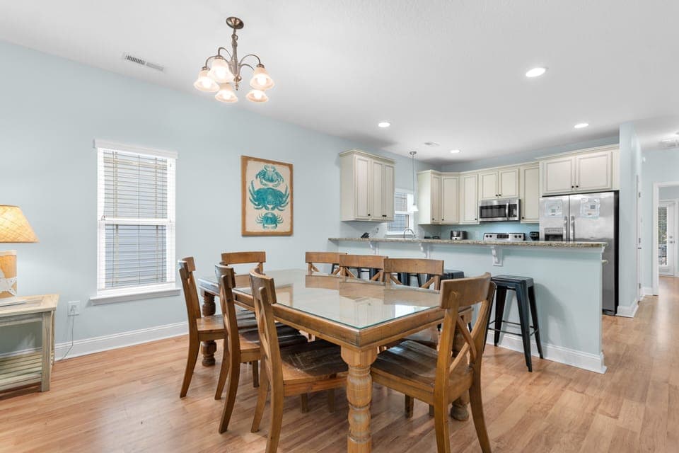 Your open-concept dining and kitchen space features coastal charm with warm wood tones, granite counters, and cheerful sea-themed decor.