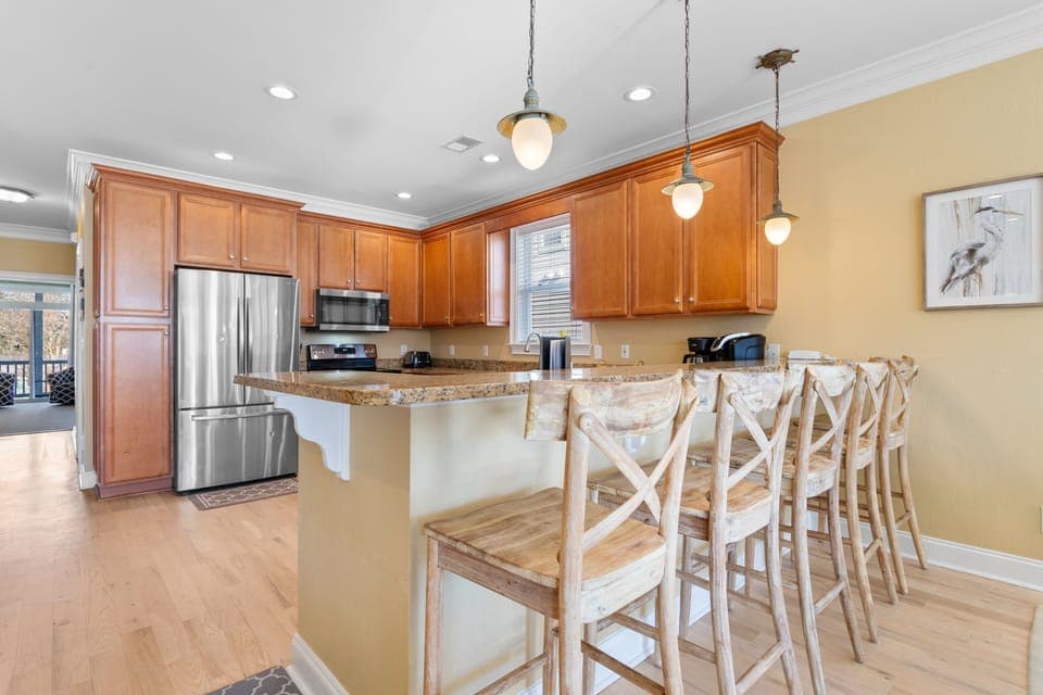 Gather around the spacious breakfast bar where rich wood cabinets and granite counters create your perfect morning coffee spot.