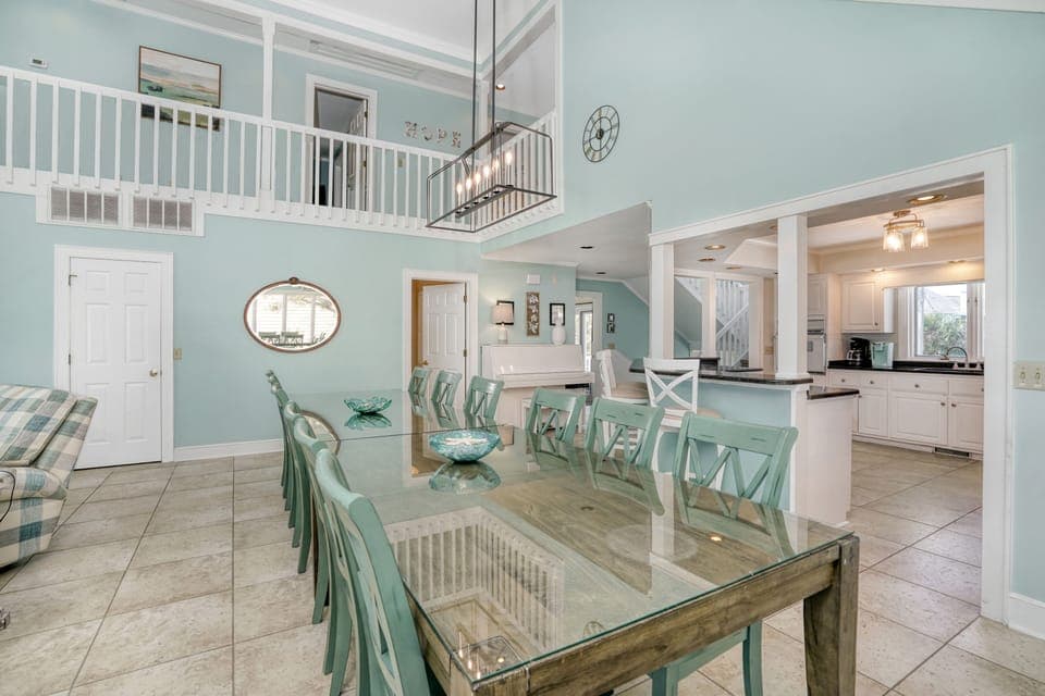 Gather around this elegant glass dining table where coastal charm meets comfort in your spacious open-plan living area.