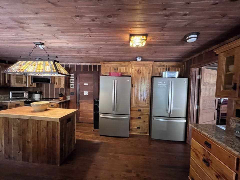Kitchen with a breakfast bar for guests and two large refrigerators.