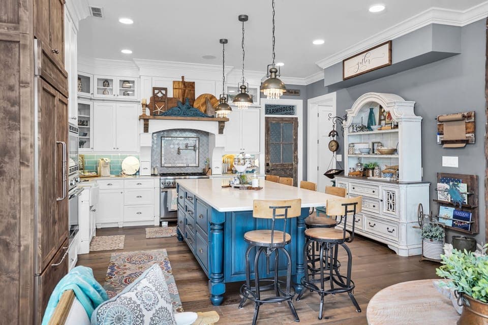 Your spacious farmhouse kitchen welcomes you with a beautiful blue island, pendant lighting, and charming rustic touches throughout.