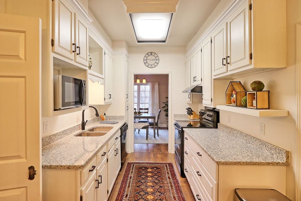 Black & white galley kitchen is fully stocked for eating in.