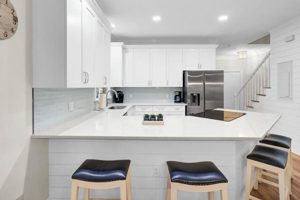 Your bright modern kitchen features sleek white cabinetry, stainless steel appliances, and a spacious island perfect for morning coffee.