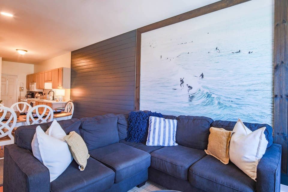 The living room features a spacious sectional and shiplap walls.