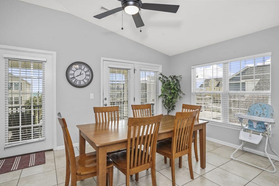 Gather around this warm dining table where family meals become cherished memories, with natural light streaming through bright windows.