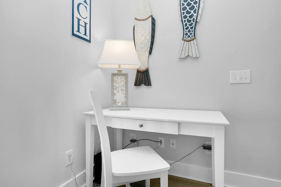 Your personal workspace awaits with a charming coastal-themed desk, complete with convenient charging outlets and gentle lighting for productive moments.