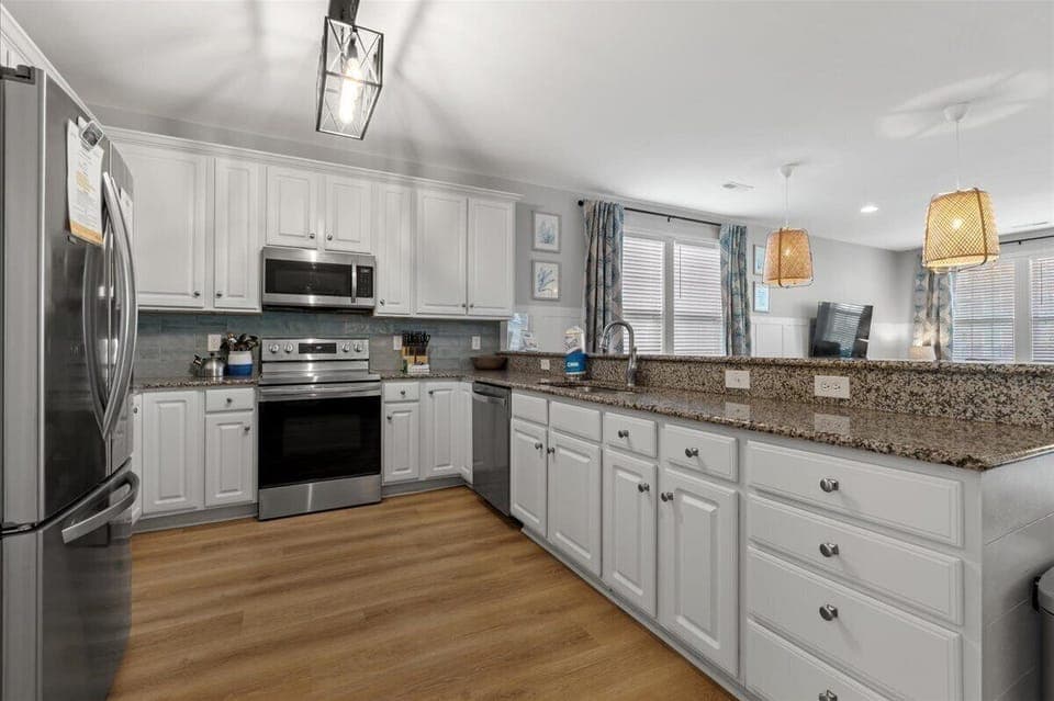 Your spacious kitchen features granite countertops, stainless steel appliances, and ample cabinet space for preparing memorable meals during your stay.