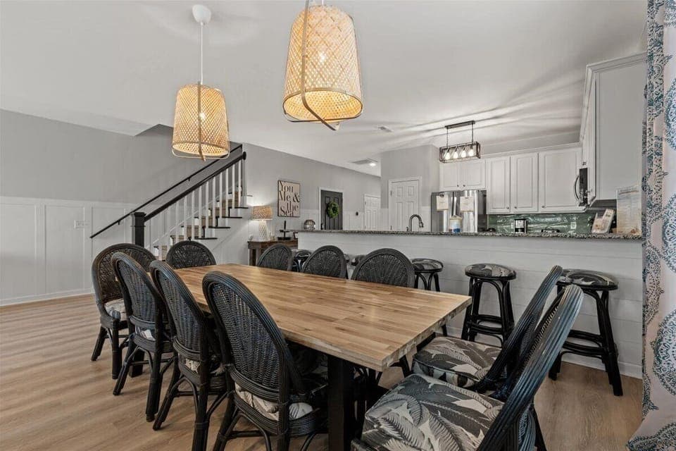 Your spacious dining area features a beautiful wood table for twelve, perfect for memorable meals with your group under warm woven pendant lights.