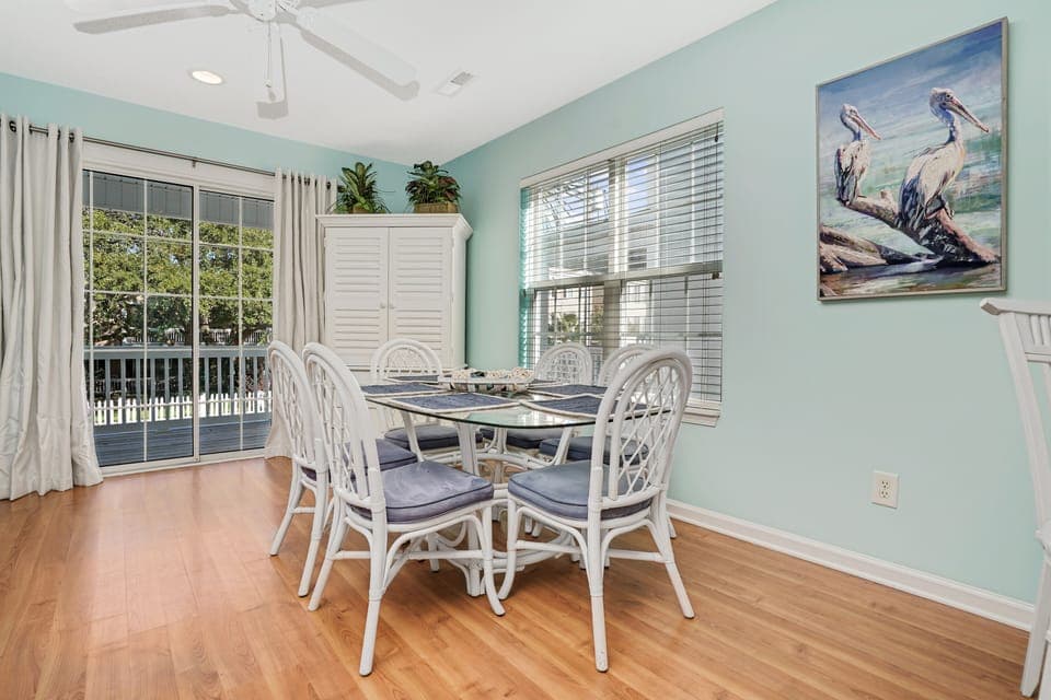 Gather around your elegant dining table where coastal artwork and serene mint walls create the perfect atmosphere for memorable meals together.
