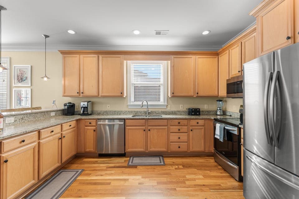 Your fully-equipped kitchen awaits with granite counters, stainless appliances, and warm wood cabinets—perfect for cooking memorable meals together.