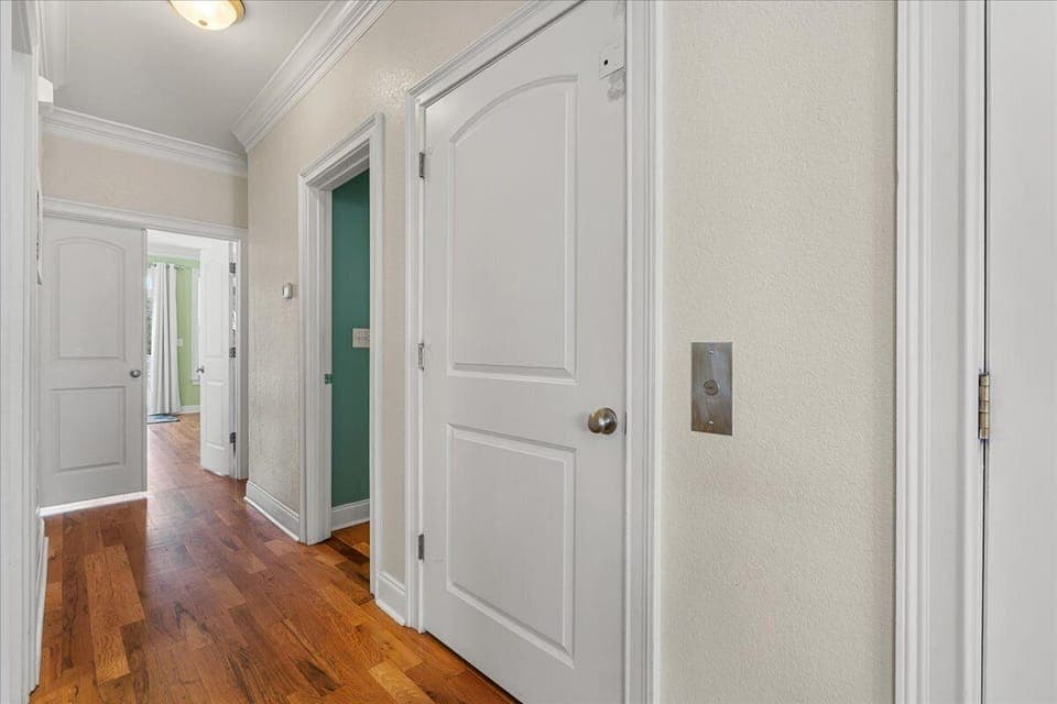 Bright hallway with gleaming hardwood floors leads you to comfortable bedrooms and spaces throughout your rental home.