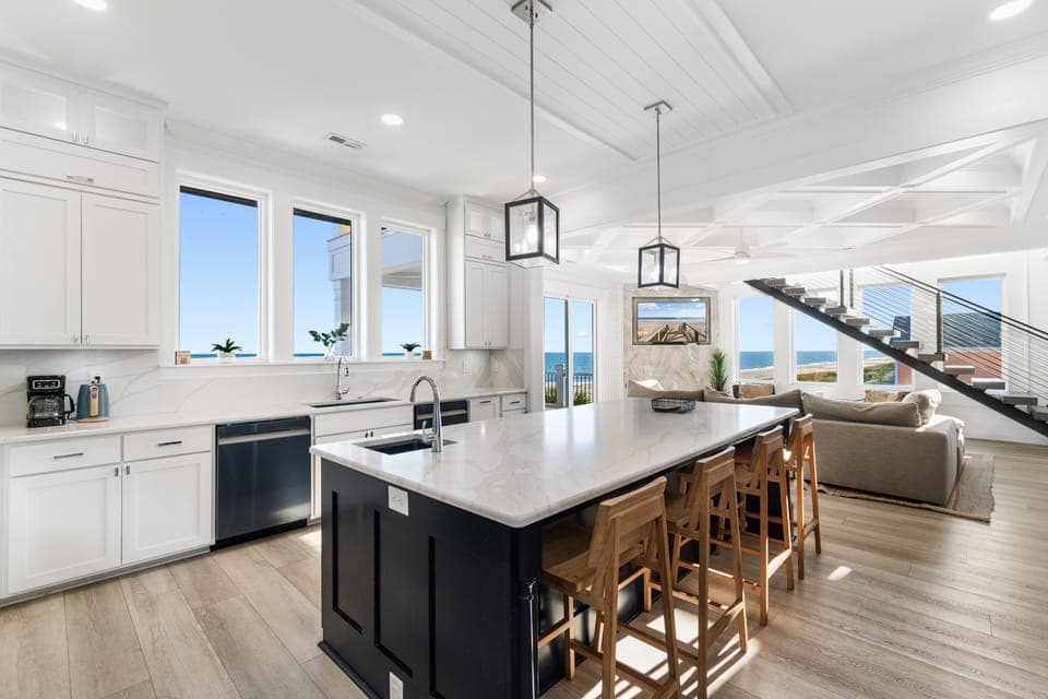 Your stunning oceanfront kitchen invites you to cook while watching waves through floor-to-ceiling windows, with marble counters and bar seating perfect for morning coffee.