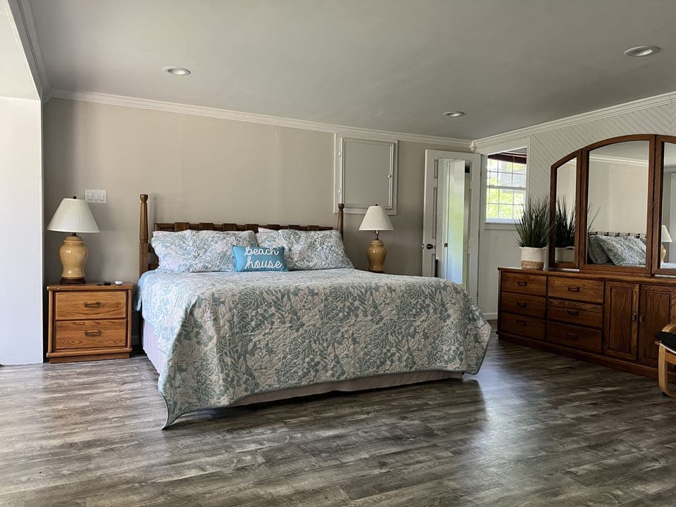 Large king size bed in the master with a dresser and walk-in closet.