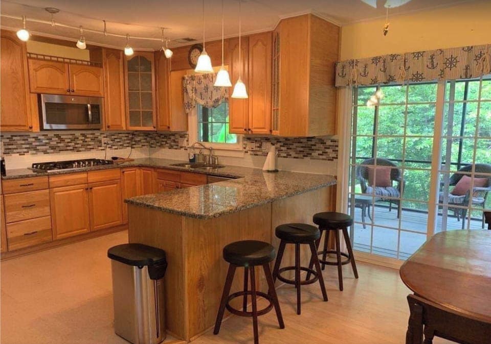 Screened in porch with seating area off of kitchen w. views of the lake.