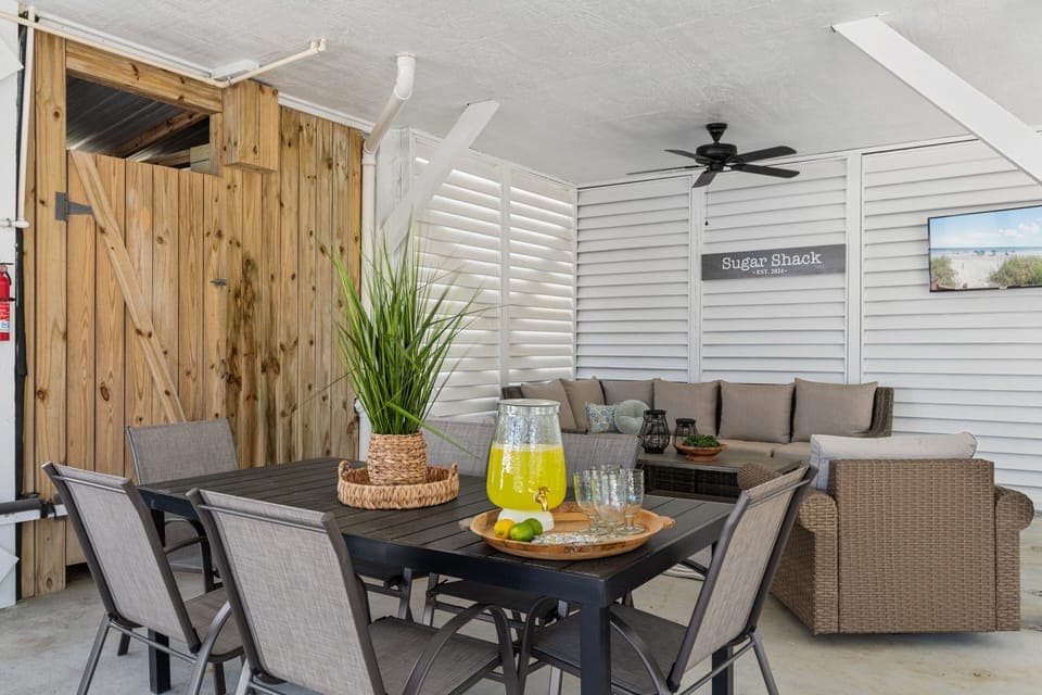 Enjoy refreshing drinks and meals in your covered outdoor dining area, complete with comfortable seating and coastal charm.