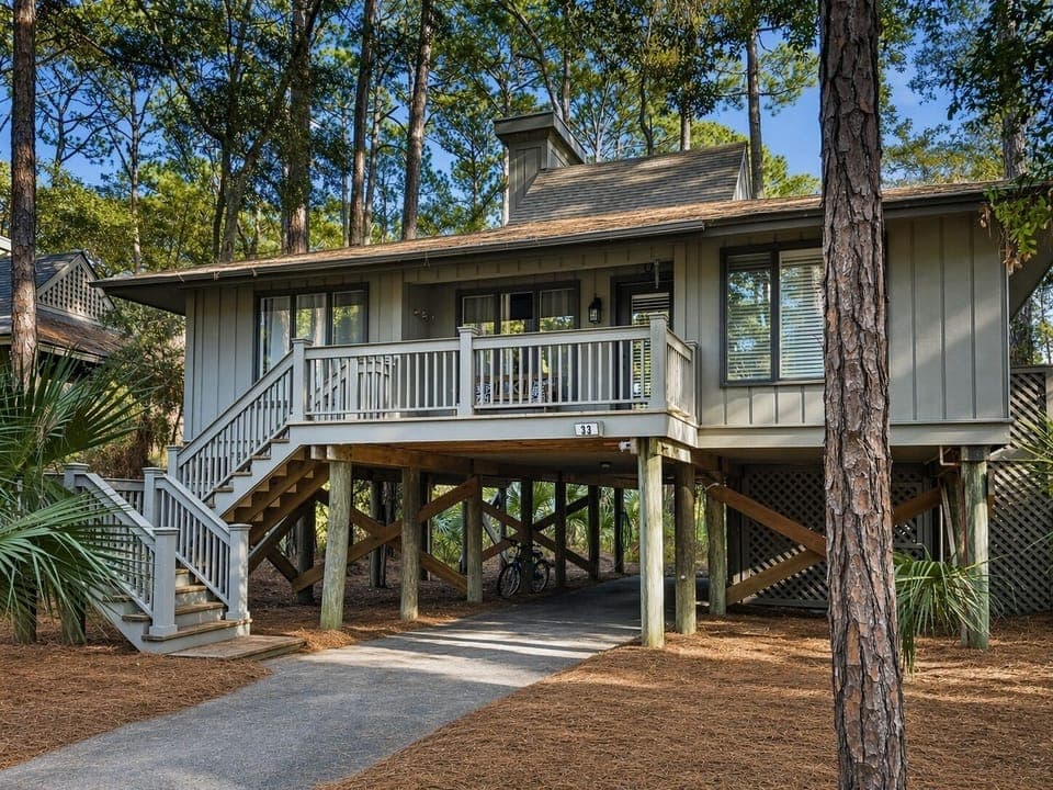 Cozy beach cottage featuring covered parking and a welcoming front deck in a peaceful coastal setting.