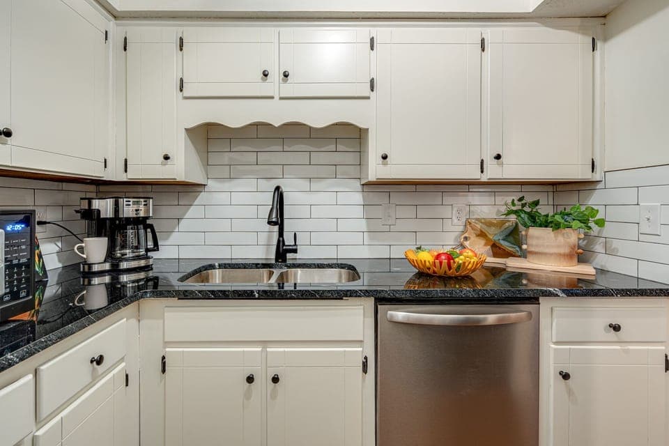 Full kitchen stocked with basic cooking essentials and stainless steel appliances.