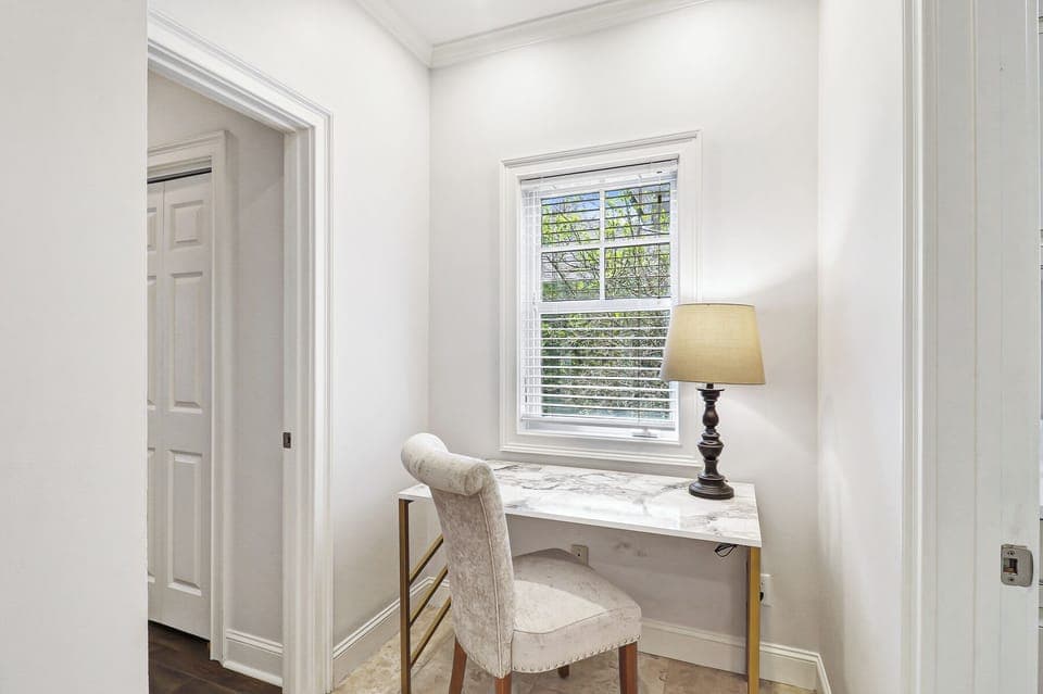 Settle into your elegant workspace featuring a marble-topped desk and plush chair, perfectly positioned by the window for natural inspiration.