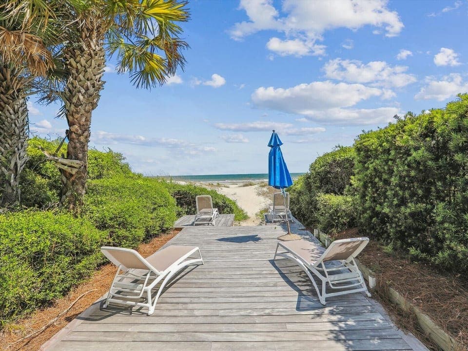 Private boardwalk to the beach with oceanfront lounging.