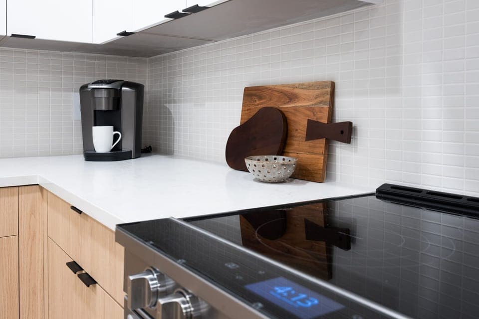 Fully equipped kitchen boasting stainless-steel appliances and an island offering bar seating. Kitchen fully stocked with all culinary essentials for ease and convenience.