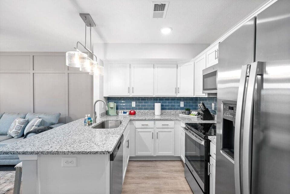 Open Kitchen and Dining Area with Stainless Steel Appliances and Kitchen Essentials