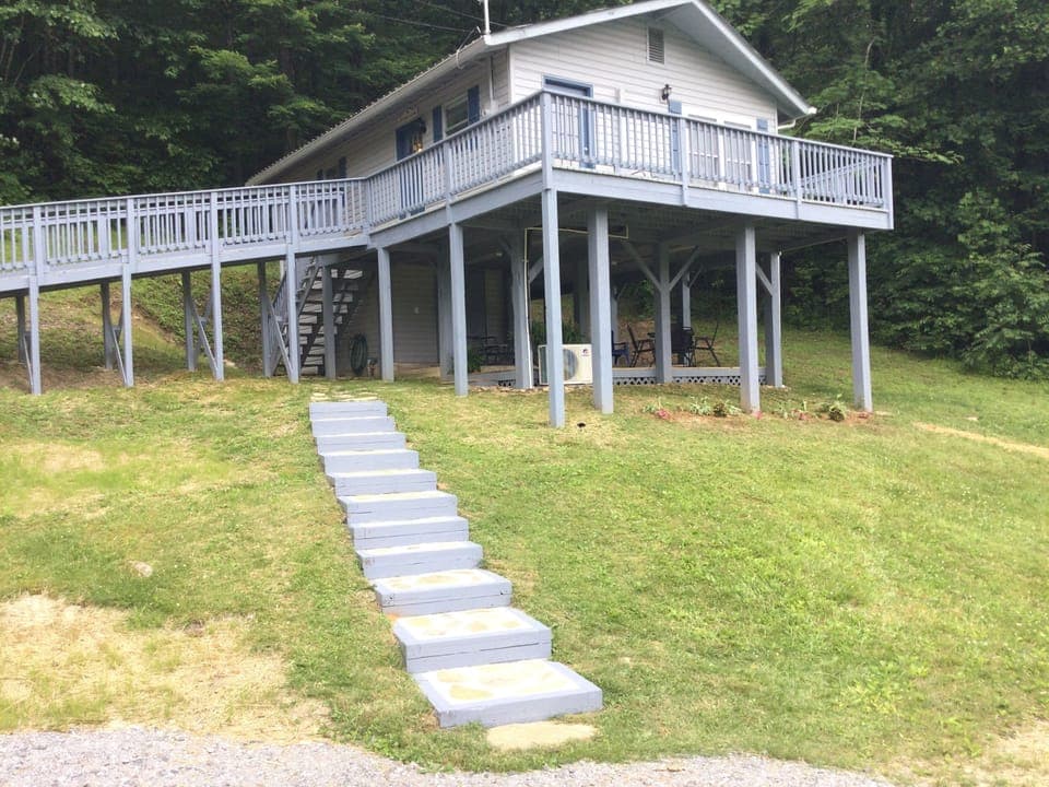 Outside view with rock steps from parking area leading to steps for front door